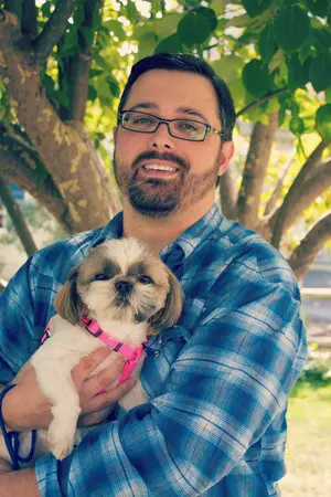 A man holding a dog in his arms.