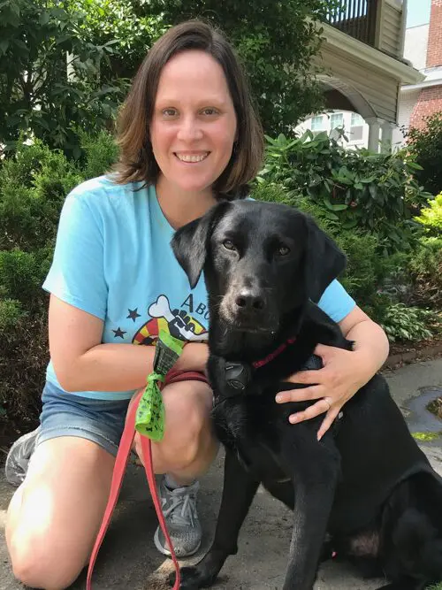 A woman sitting on the ground with her dog.