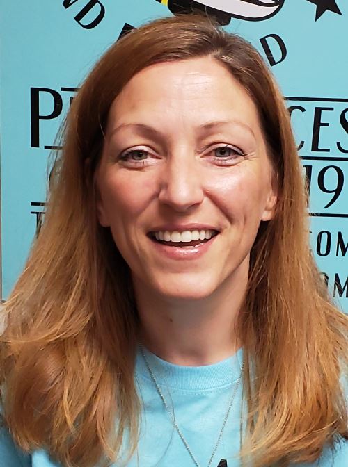 A woman with long hair smiles for the camera.