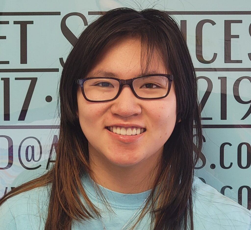 A woman with glasses smiling for the camera.