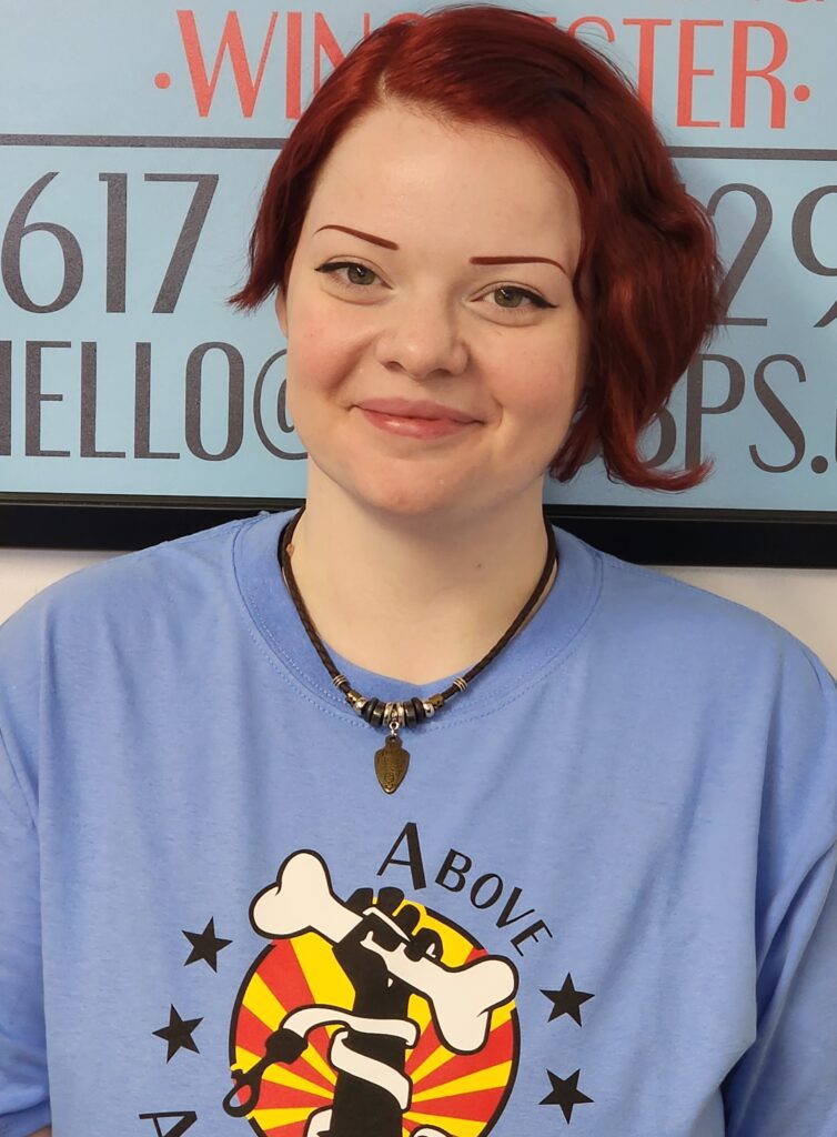 A woman with red hair wearing a blue shirt.