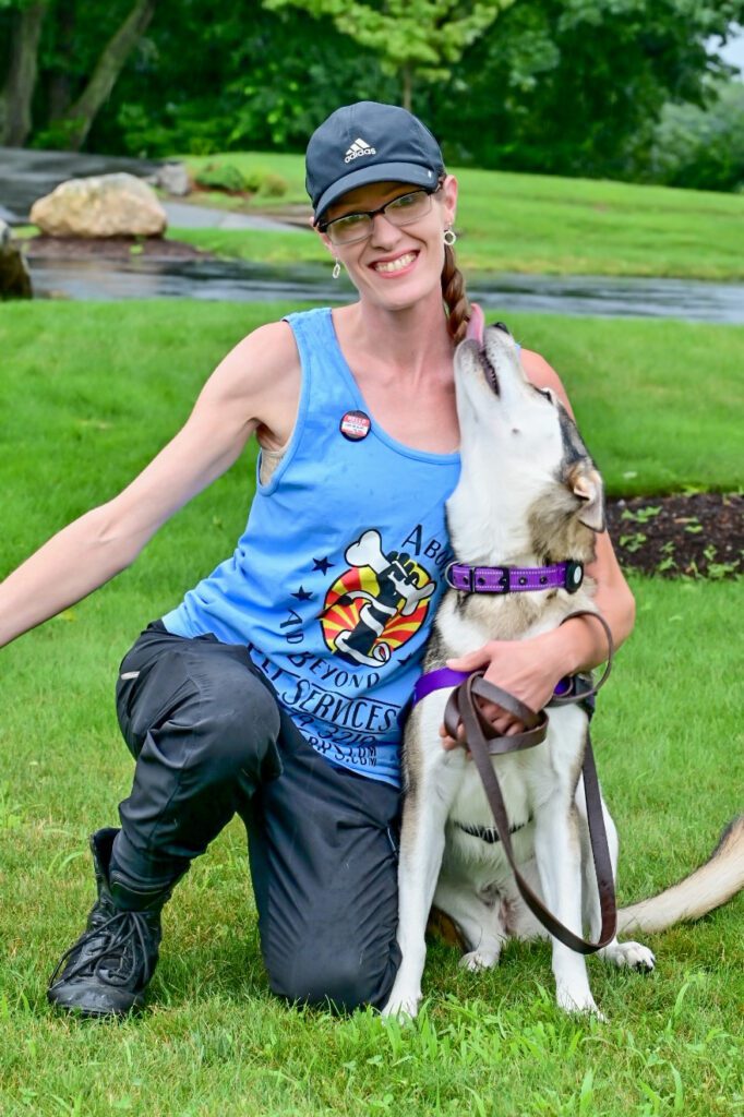 A woman and her dog are posing for the camera.