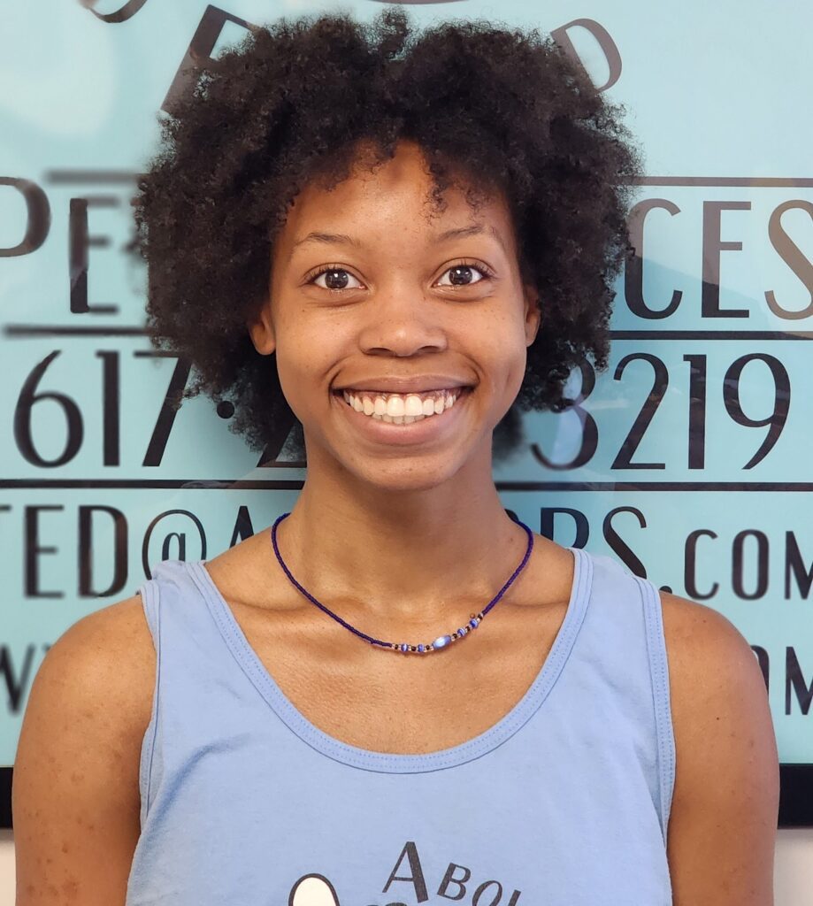 A woman with afro hair smiling for the camera.