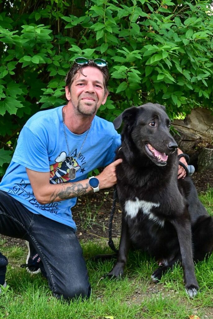 A man and his dog pose for the camera.