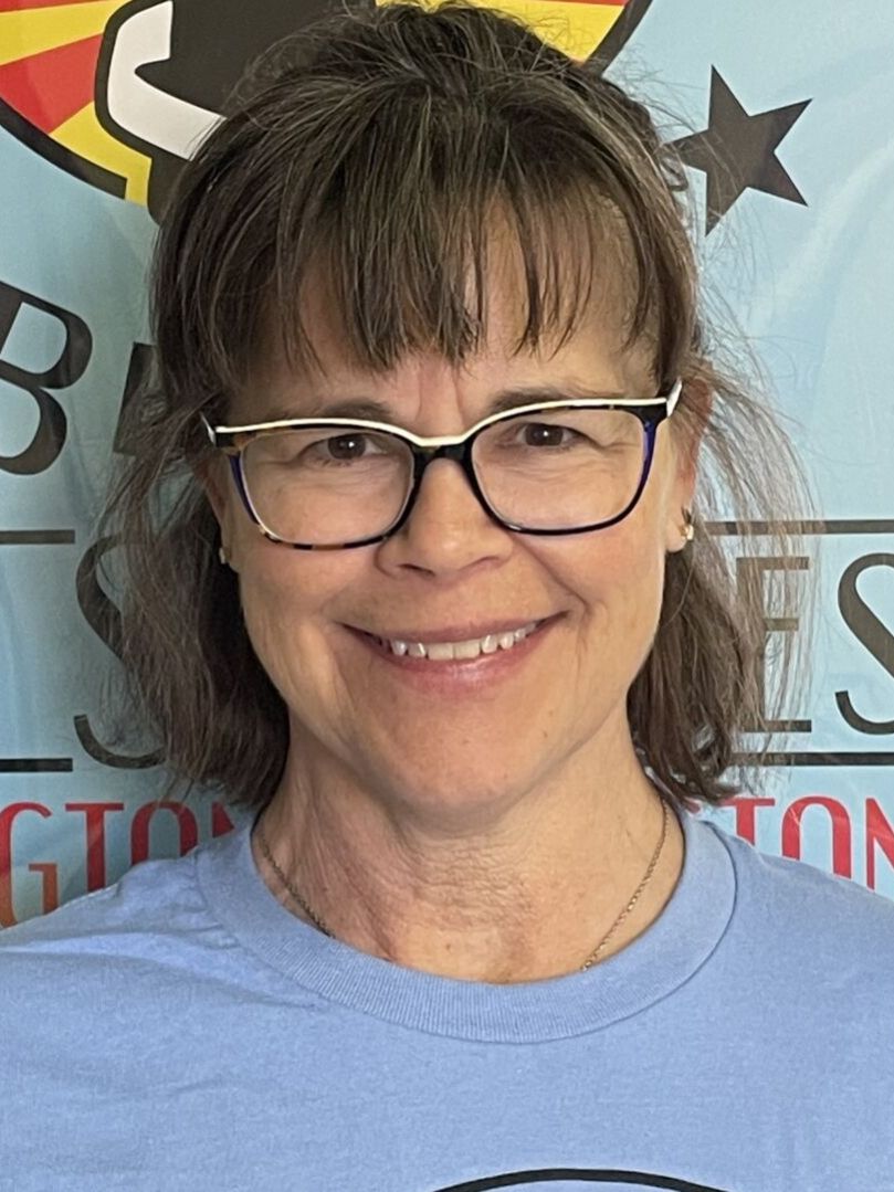 Smiling woman wearing glasses and blue shirt